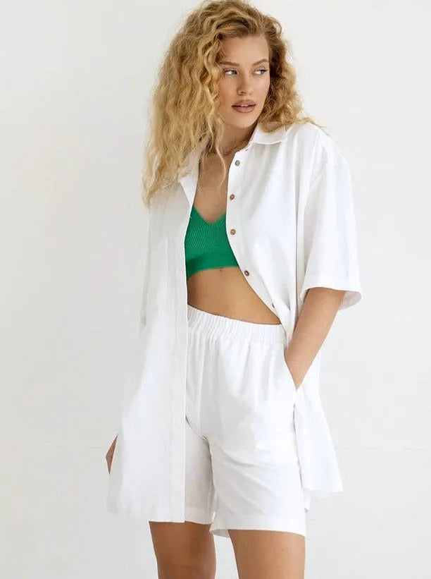 Frau in weißem, lockerem Hemd und Shorts, kombiniert mit grünem Top. Sommermode, lässiger Stil, trendige Damenbekleidung, Freizeitlook.