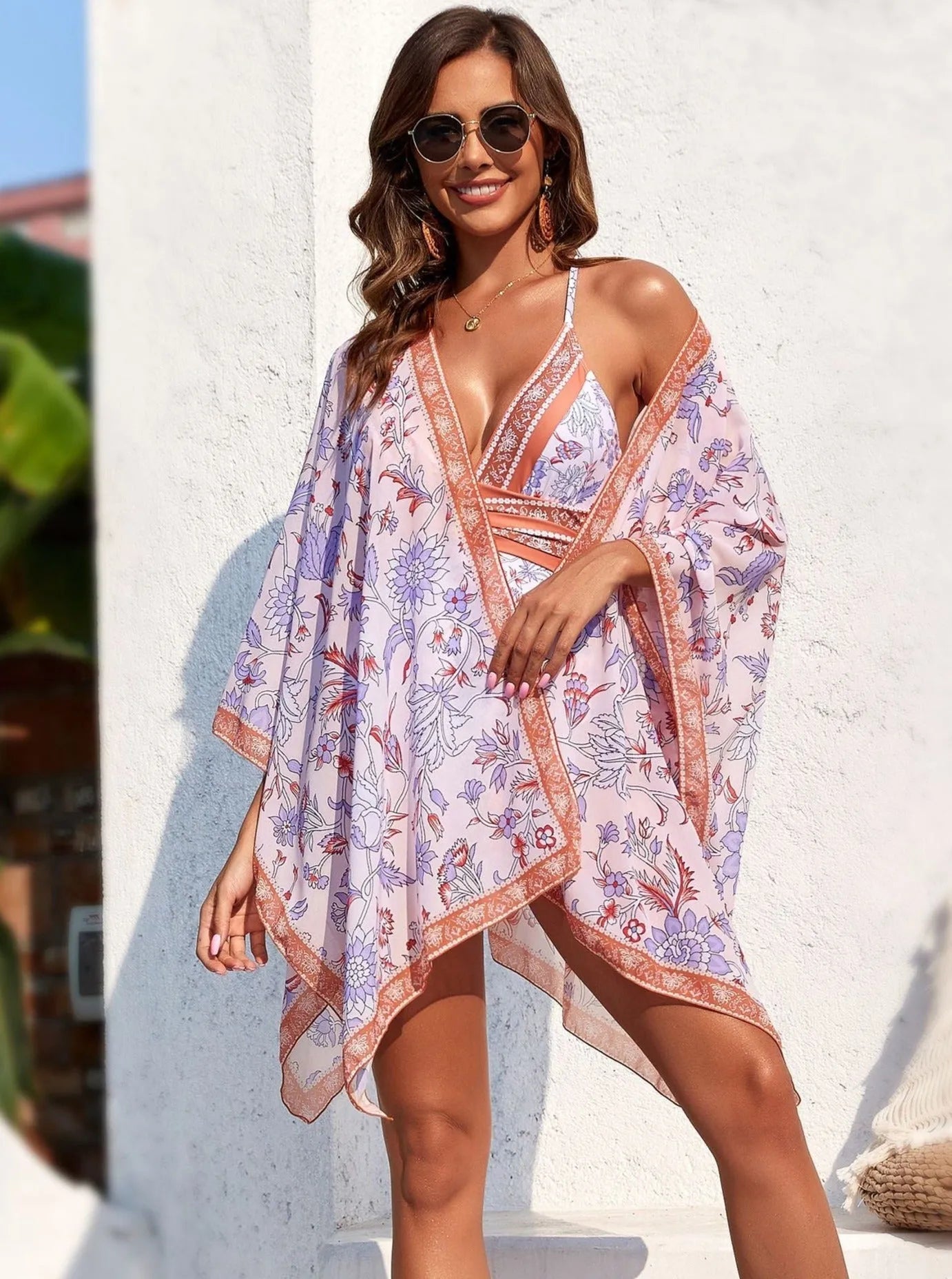 Frau in geblümtem Strandkaftan, Sonnenbrille und Bikini. Sommermode, Strandkleidung, stilvoller Kaftan, Damenmode, Urlaubsoutfit.