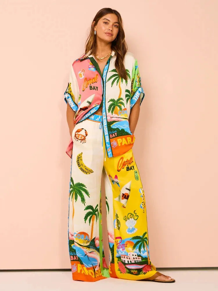 Farbintensiver Damen-Pyjama mit tropischen Motiven, Palmen und Schriftzügen. Perfekt für Sommernächte, bequem und stilvoll.