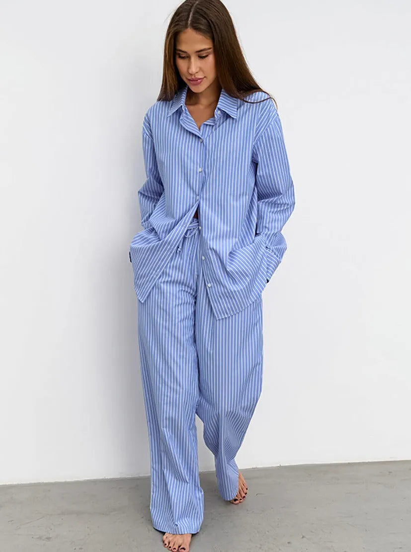 Frau in gestreiftem blauen Pyjama-Set, lässig und bequem, ideal für Nachtwäsche. Modetrend, Damenmode, Schlafanzug, entspannter Stil.
