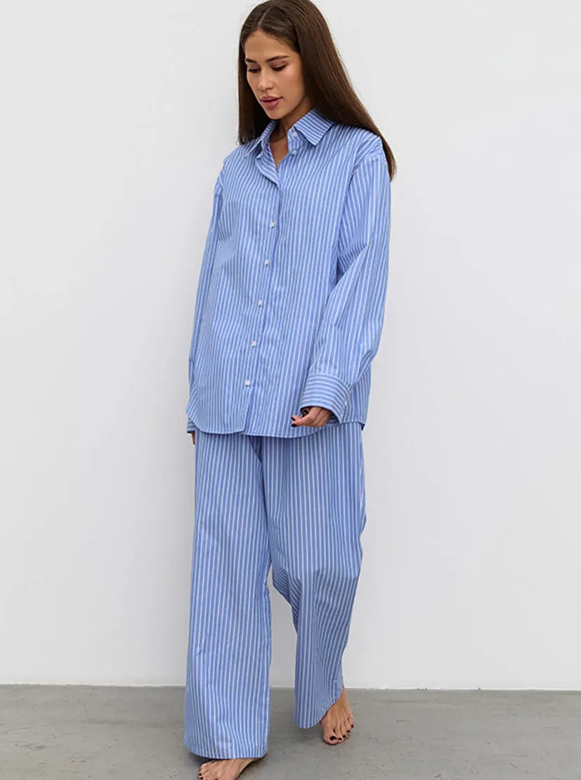 Frau in gestreiftem blauen Pyjama-Set, bestehend aus Hemd und Hose. Bequemes Nachtwäsche-Outfit, ideal für entspannte Abende zu Hause.