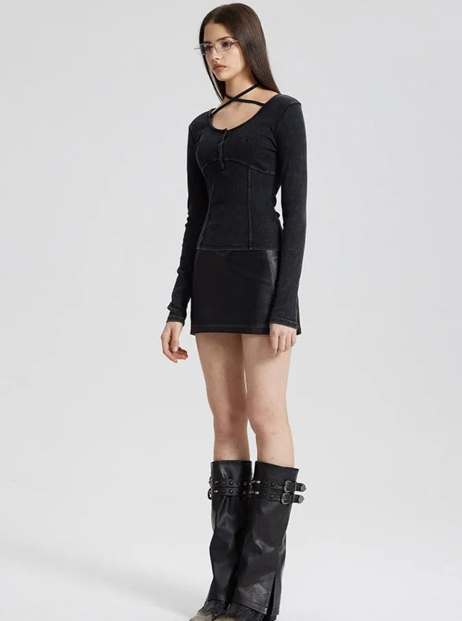 Frau in schwarzem, figurbetontem Kleid mit langen Ärmeln und modischen Stiefeln. Trendige Damenmode, elegantes Design, stilvolle Kleidung.