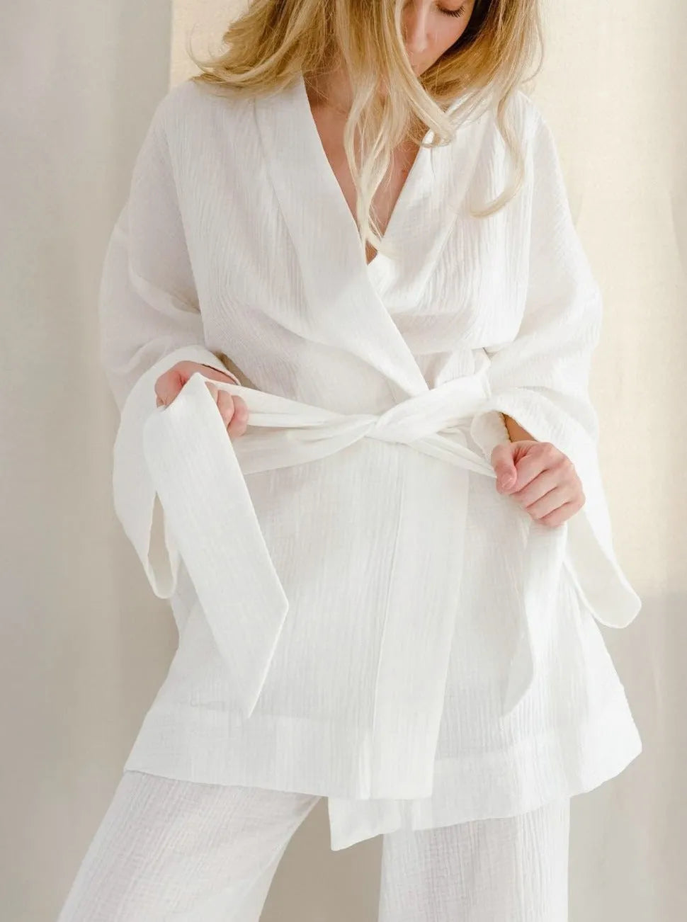 Frau in weißem Kimono aus Baumwolle, lässig und elegant, ideal für Freizeit und Entspannung. Perfekt für stilvolle, bequeme Mode.