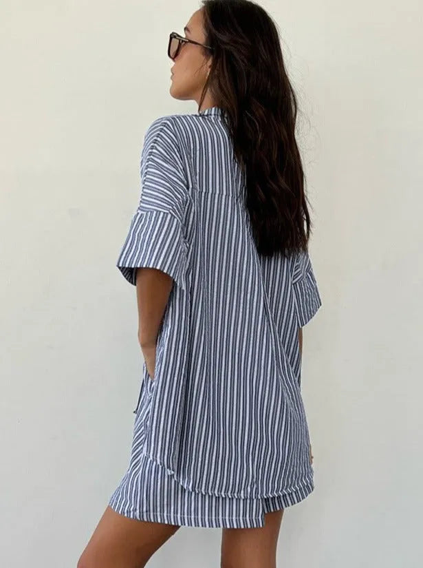 Frau in gestreiftem Hemdkleid, lässiger Sommerlook, blau-weiß, modisch, bequem, ideal für Strand oder Freizeit, trendige Damenmode.