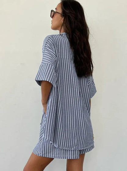 Frau in gestreiftem Hemdkleid, lässiger Sommerlook, blau-weiß, modisch, bequem, ideal für Strand oder Freizeit, trendige Damenmode.