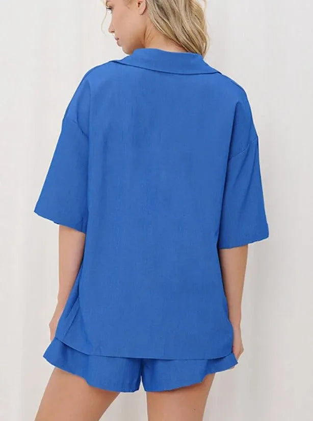 Frau in blauem Pyjama-Set aus Baumwolle, bestehend aus kurzärmligem Hemd und Shorts. Bequem, modisch, ideal für Sommernächte.
