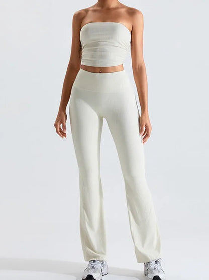 Damen-Outfit: Weißes, schulterfreies Top und passende Hose, ideal für Sommermode. Perfekt für Freizeit und stilvolle Alltagslooks.
