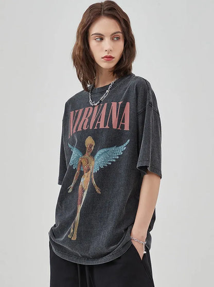 Frau trägt ein schwarzes Nirvana-Bandshirt mit Engelsmotiv, lässiger Stil, ideal für Rock-Mode, Streetwear, Vintage-Look.
