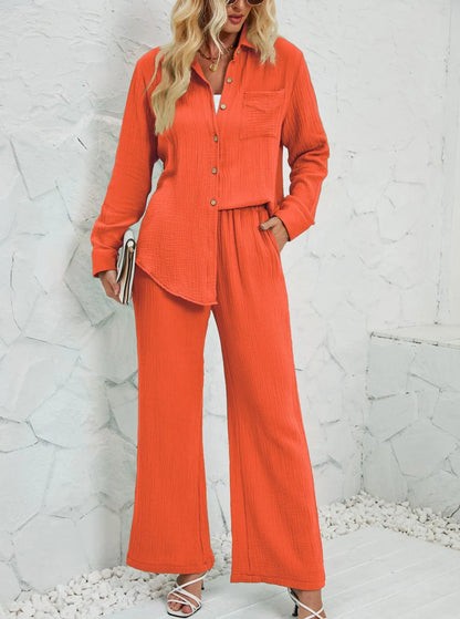Frau in orangefarbenem Leinenanzug, bestehend aus Hemd und Hose, vor weißer Wand. Modetrend, Damenbekleidung, Sommeroutfit, stilvoll.