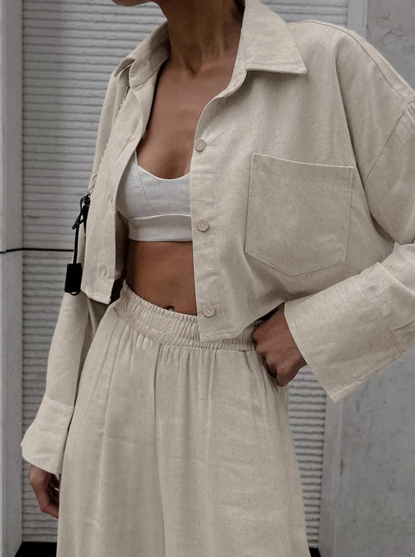 Damen-Outfit aus beigem Leinen: Cropped-Hemdjacke und High-Waist-Hose. Perfekt für minimalistischen, eleganten Sommerlook.