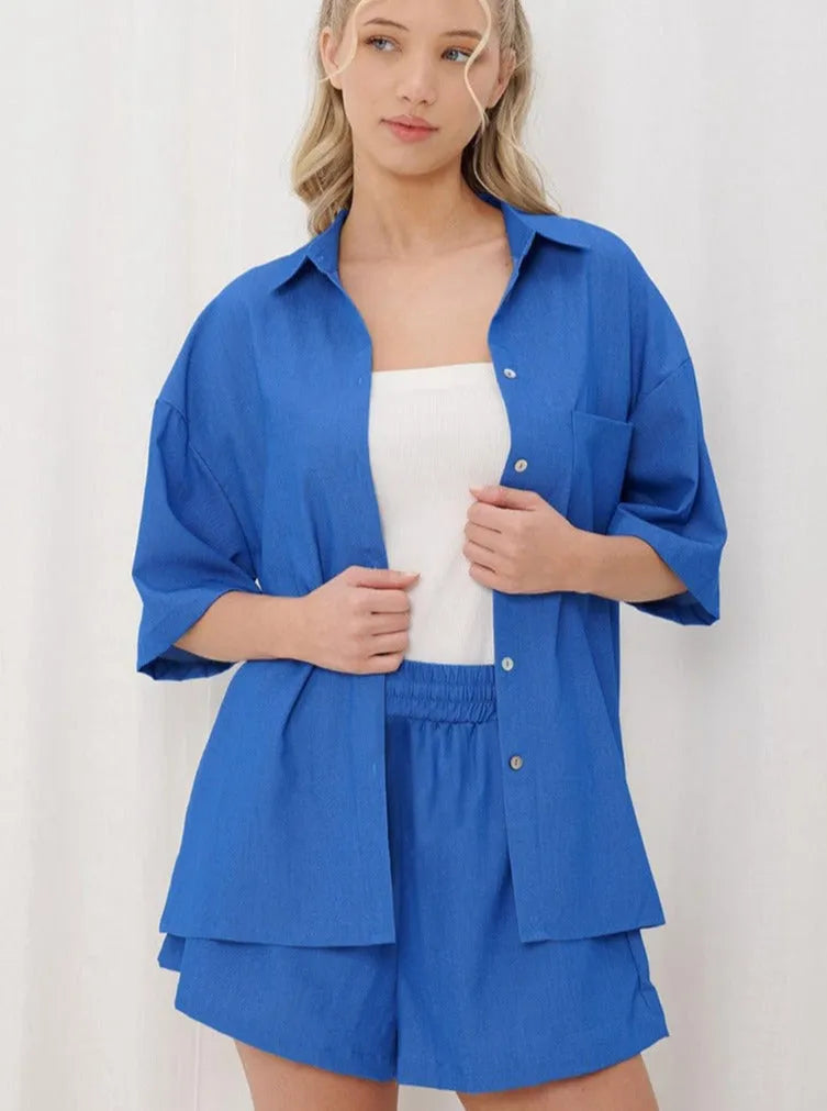 Frau in blauer Bluse und Shorts, lässiger Sommerlook, modische Damenbekleidung, trendige Freizeitmode, stilvolles Outfit für warme Tage.