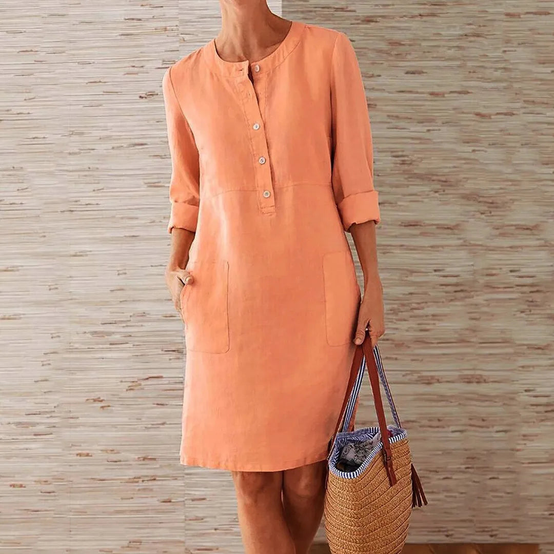 Damen Leinenkleid in Orange, knielang mit Knopfleiste und Taschen, ideal für Sommermode. Perfekt kombiniert mit einem geflochtenen Korb.
