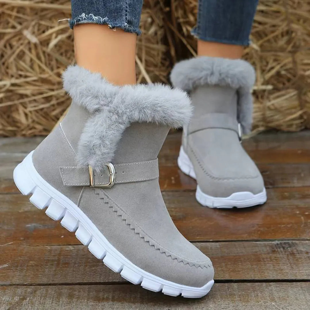 Graue Winterstiefel mit Kunstfell, rutschfester Sohle und Schnalle. Perfekt für kalte Tage. Damenmode, warme Stiefel, bequemes Design.