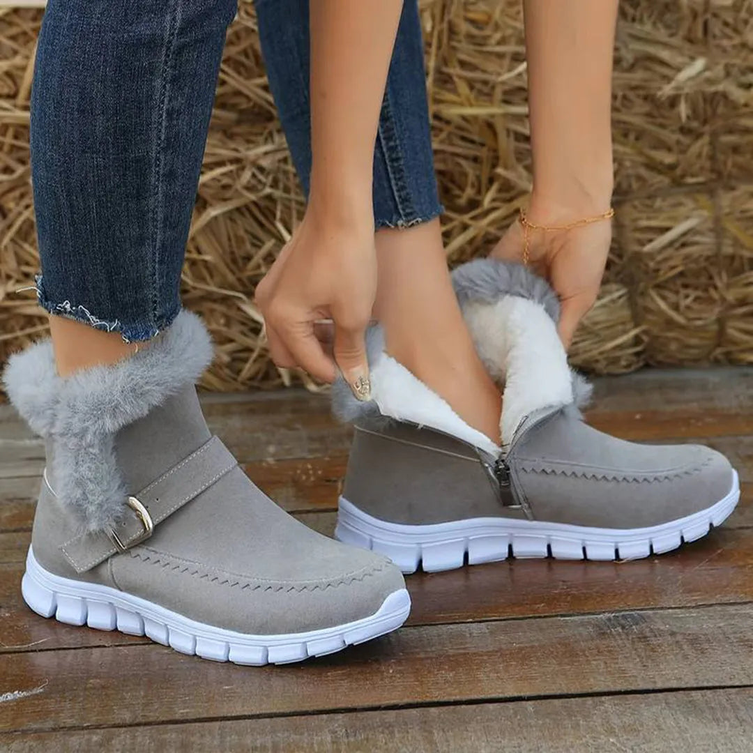Graue Winterstiefel mit Kunstfellfutter, Reißverschluss und Schnalle, ideal für kalte Tage. Bequeme Damenstiefel, modisch und warm.