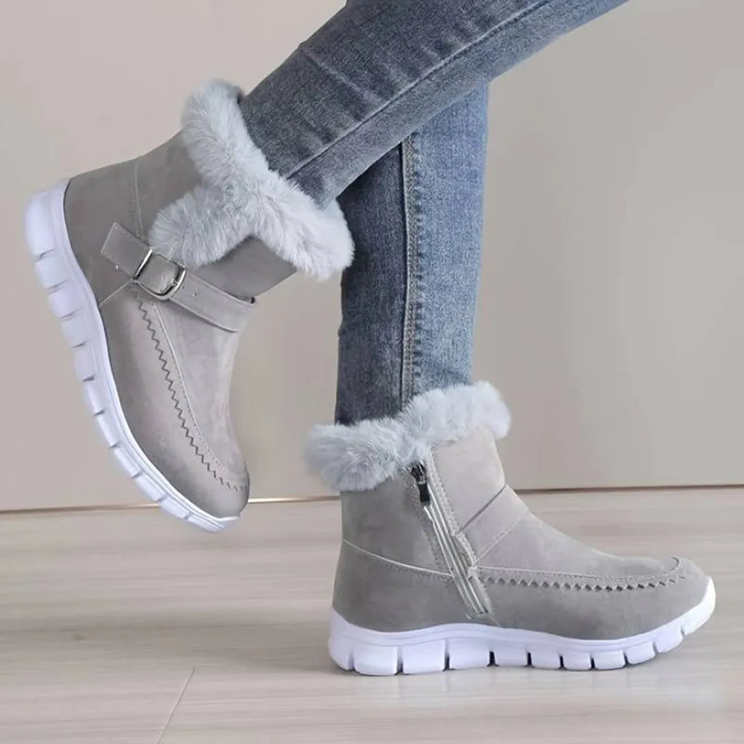 Graue Winterstiefel mit Kunstfell, Reißverschluss und Schnalle, ideal für kalte Tage. Bequeme Damenstiefel, modisch und warm.
