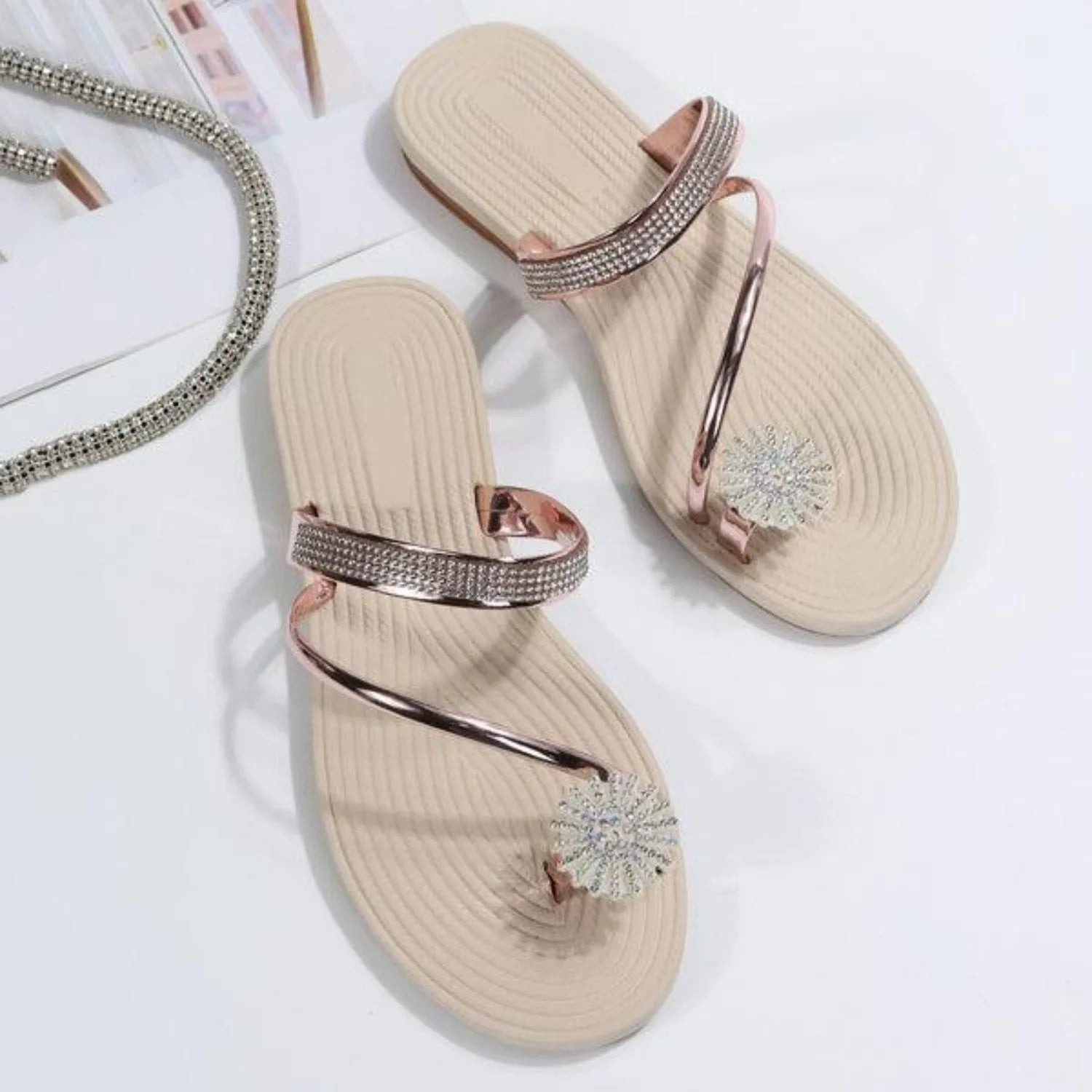 Beige Sandalen mit Strassverzierung und Blumenapplikation, ideal für Sommermode. Damen-Sommerschuhe, elegant und bequem.