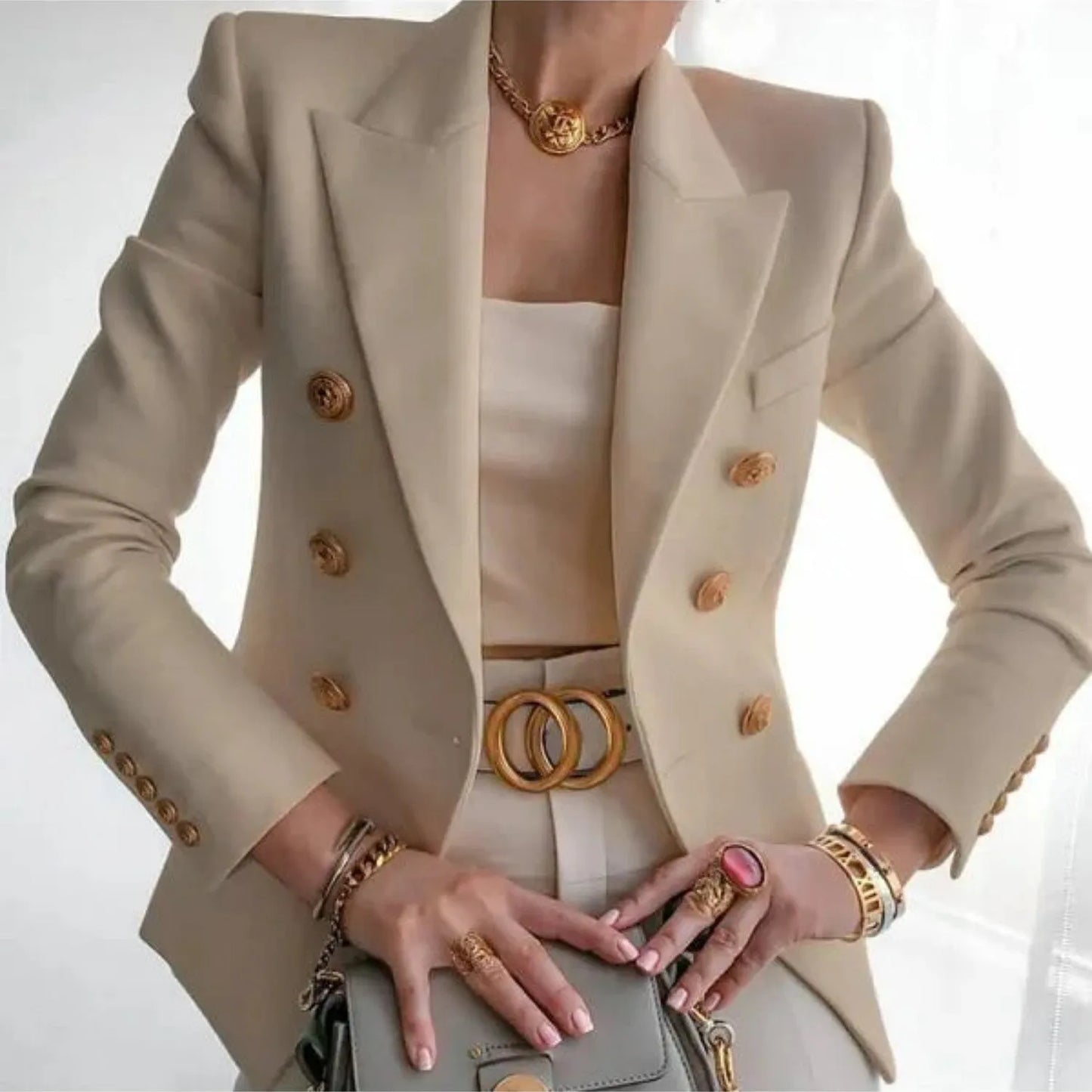 Eleganter Damenblazer in Beige mit doppelreihigen Knöpfen, kombiniert mit stilvollen Accessoires. Perfekt für Business- und Freizeitmode.