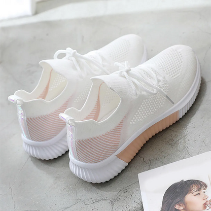 Weiße Sneaker mit rosa Akzenten, atmungsaktivem Mesh-Obermaterial und rutschfester Sohle. Perfekt für Damenmode und sportlichen Lifestyle.