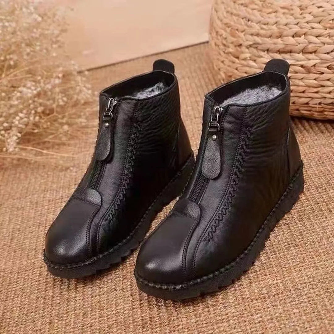 Schwarze Lederstiefel mit Reißverschluss, warm gefüttert, auf Juteteppich. Perfekt für Herbst und Winter. Modische, bequeme Damenstiefel.