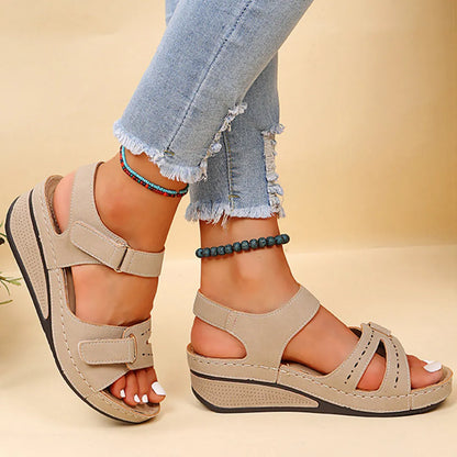 Beige Sandalen mit Keilabsatz, ideal für Sommermode. Komfortable Damen-Schuhe aus Leder, perfekt für Freizeit und Strand. Trendige Fußbekleidung.