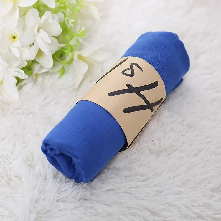 Blaues Musselintuch auf weichem Teppich, ideal für Babys. Hochwertige Baumwolle, vielseitig einsetzbar. Perfekt als Geschenk oder für den Alltag.