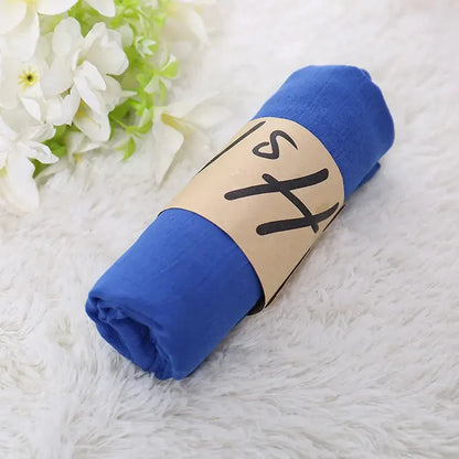 Blaues Musselintuch auf weichem Teppich, ideal für Babys. Hochwertige Baumwolle, vielseitig einsetzbar. Perfekt als Geschenk oder für den Alltag.