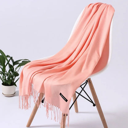 Weicher, rosa Schal auf modernem Stuhl, ideal für stilvolle Wohnkultur. Perfekt als Geschenk oder für gemütliche Abende. Hochwertige Materialien.