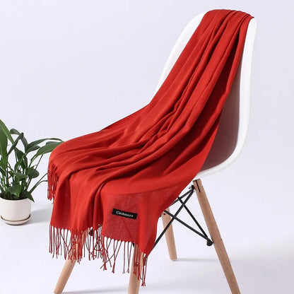 Roter Kaschmirschal auf weißem Stuhl, elegantes Design, weiche Textur, ideal für Herbst und Winter. Perfekt als modisches Accessoire.