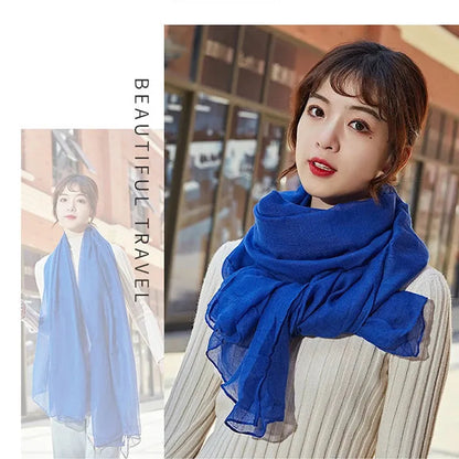 Frau mit blauem Schal, modisches Accessoire, Herbstmode, eleganter Look, stilvoller Schal, Damenbekleidung, trendige Outfits, Reisebekleidung.