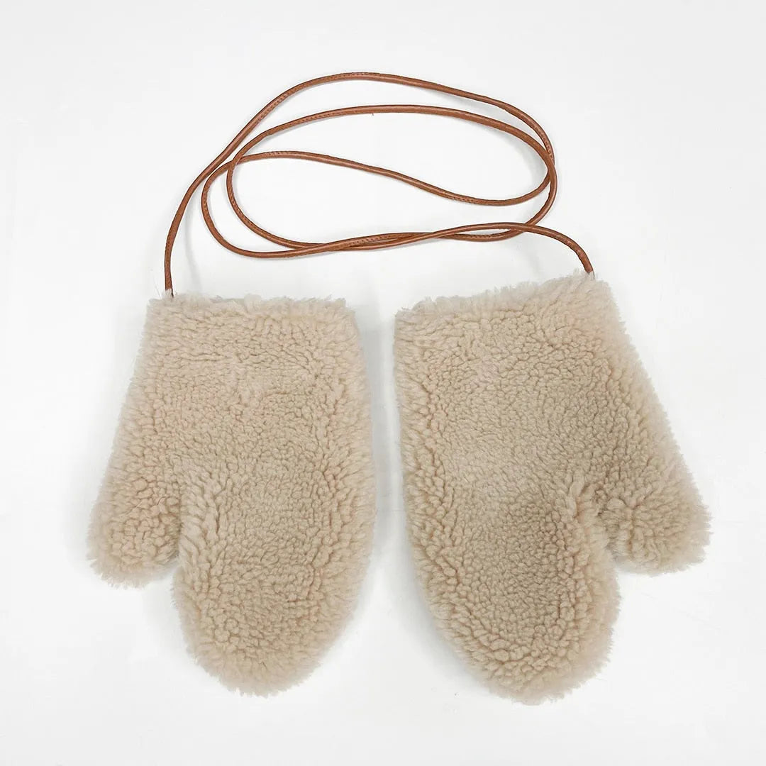 Kuschelige Fäustlinge aus Lammfell mit Lederschnur, ideal für kalte Wintertage. Perfekte Kombination aus Wärme und Stil.