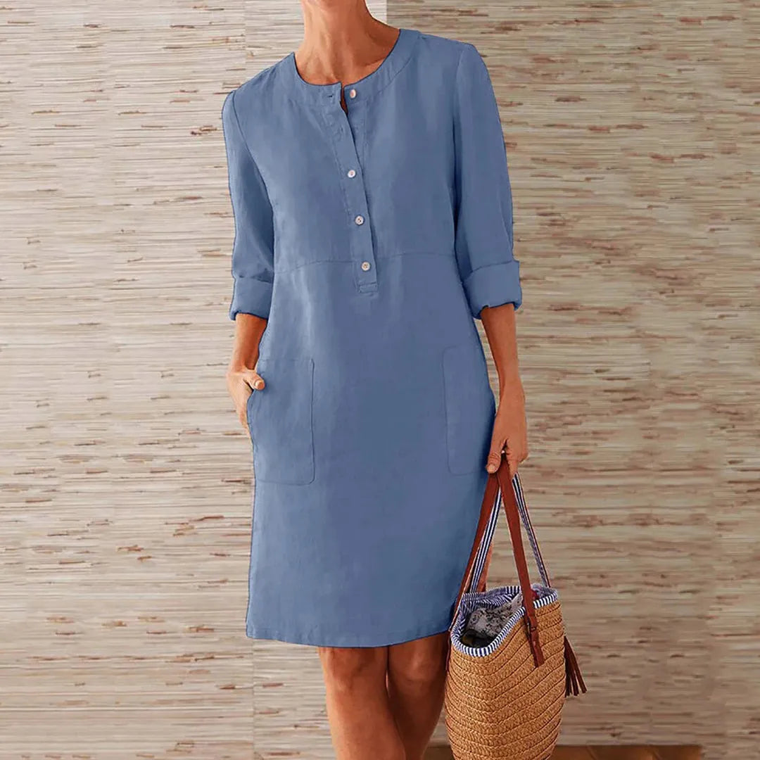 Damen Leinenkleid in Himmelblau mit Knopfleiste und Taschen, ideal für Sommermode. Perfekt kombiniert mit einem geflochtenen Strohtasche.