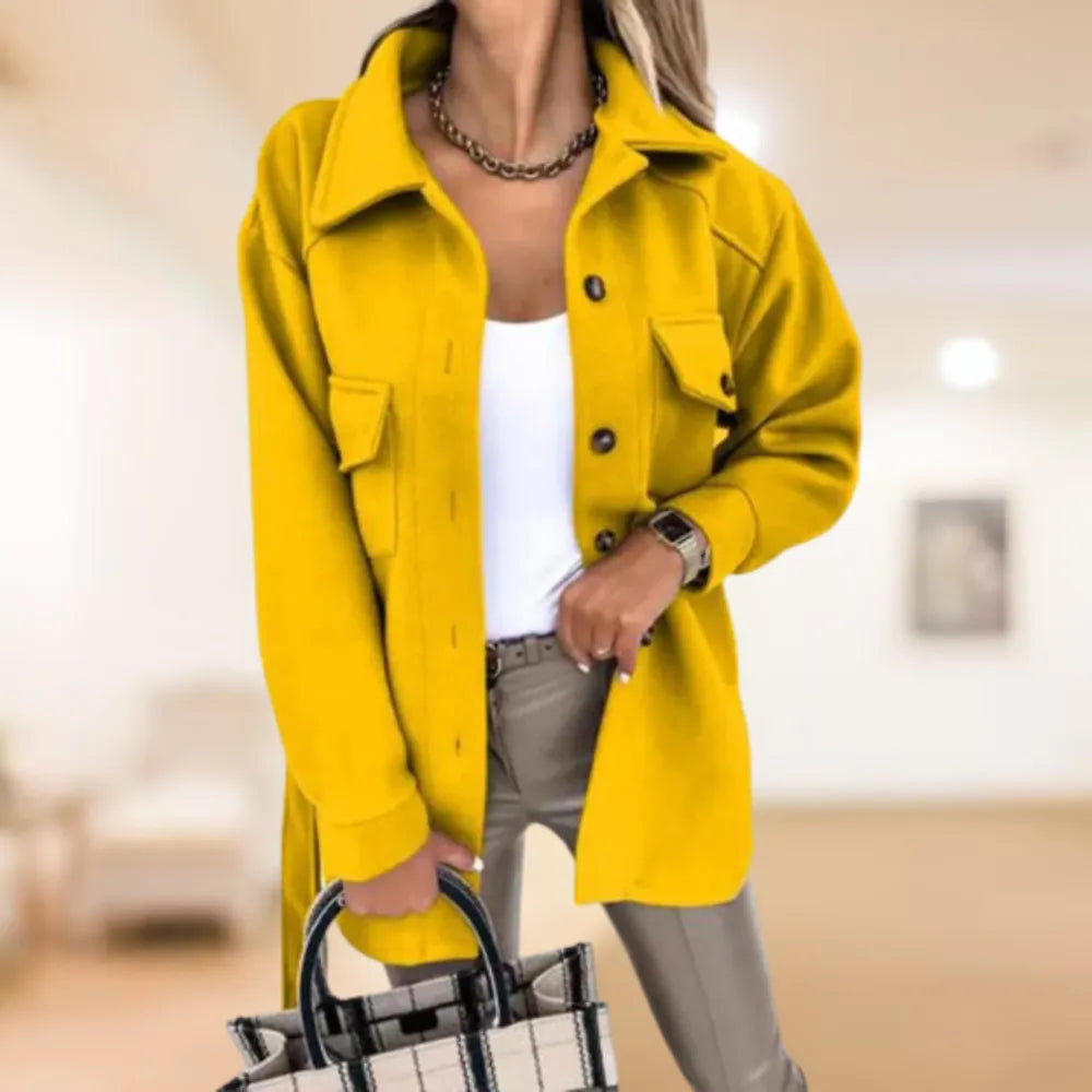 Frau in gelber Jacke, weißem Top und beiger Hose hält karierte Tasche. Modetrend, Damenmode, Herbstoutfit, stilvolle Kleidung, Freizeitlook.