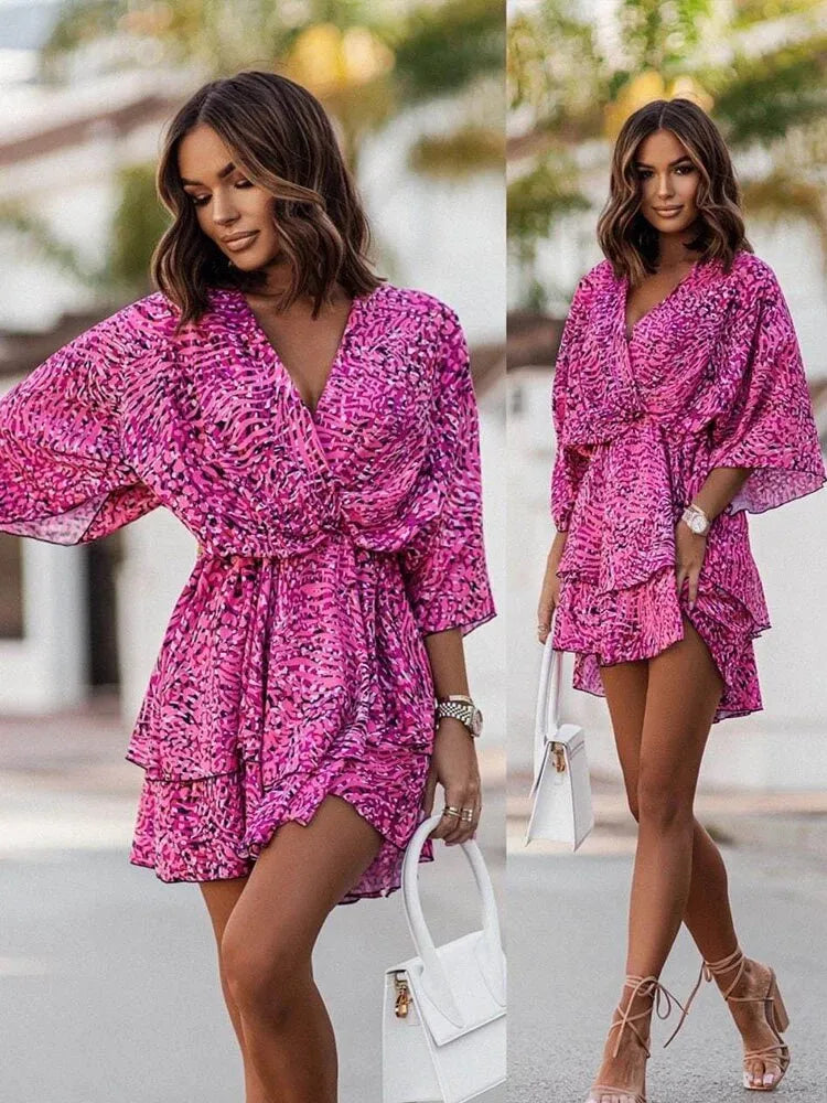 Feminines, kurzes Kleid mit floralem Print, V-Ausschnitt und weiten Ärmeln. Perfekt für Sommermode, trendige Damenbekleidung, eleganter Look.