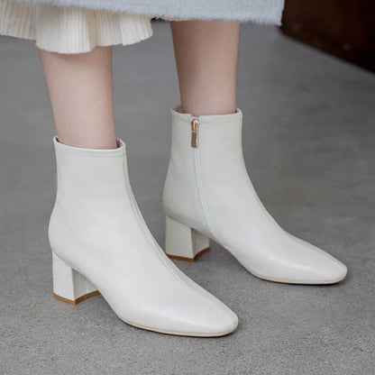 Elegante weiße Damenstiefeletten mit Blockabsatz und Reißverschluss, ideal für Herbstmode. Perfekt kombinierbar zu Röcken und Hosen.