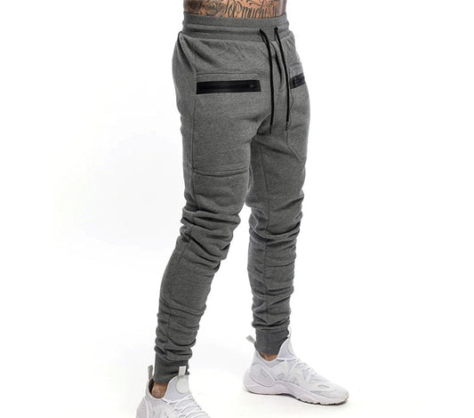 Graue Jogginghose für Herren, Slim Fit, mit schwarzen Reißverschlusstaschen, sportlich, bequem.