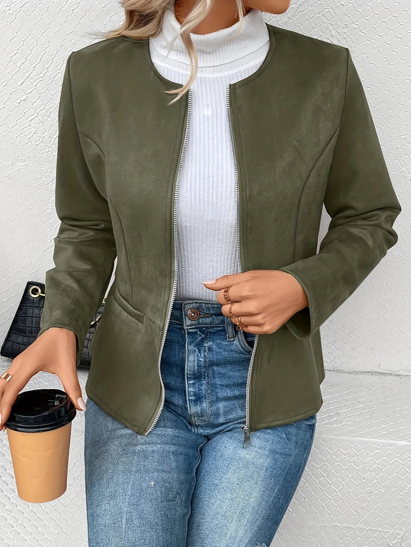 Damenjacke in Olivgrün, kombiniert mit weißem Rollkragenpullover und blauer Jeans. Modetrend, stilvolle Herbstbekleidung, lässiger Look.