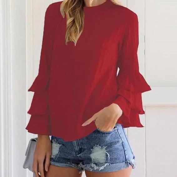 Rote Damenbluse mit Rüschenärmeln, kombiniert mit zerrissenen Jeansshorts. Modetrend, stilvolle Damenbekleidung, Freizeitlook.