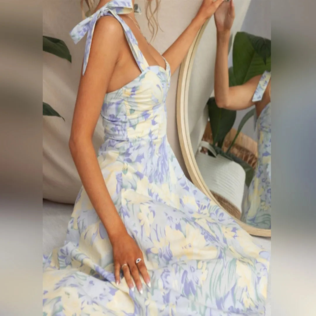 Elegantes Sommerkleid mit floralen Mustern in Blau und Gelb, ärmellos mit Schleifen-Trägern. Perfekt für Damenmode, Sommeroutfits, Freizeitkleidung.